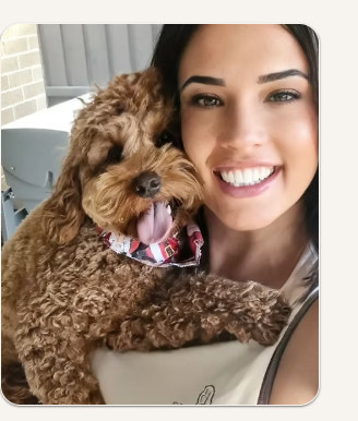 Vee, founder of Lulu & Co Pet Care, holding a dog in her arms